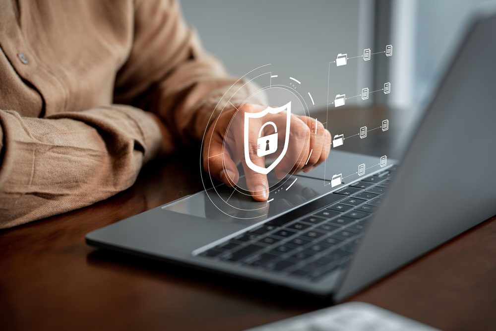 A close-up view shows a person’s hand poised over the touchpad of a laptop, with a translucent digital lock icon and shield graphic superimposed on the image, symbolizing cybersecurity and data protection. Surrounding the lock are floating folder icons connected by lines, representing a secure and organized digital workflow. The person’s attire and the polished wooden desk suggest a professional setting. This image reflects Postalocity’s commitment to security and compliance, especially for financial institutions handling sensitive data. Every piece of mail is processed under strict protocols, ensuring confidentiality, regulatory adherence, and peace of mind for secure document delivery.